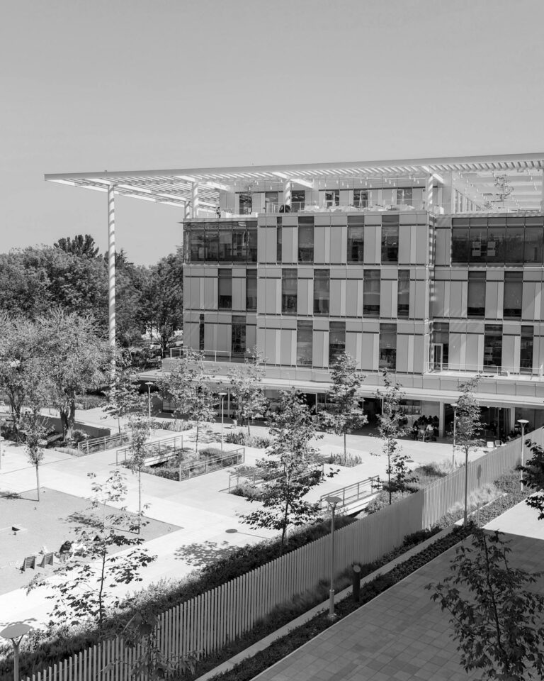 Exterior view of a sleek modern university campus building surrounded by trees.